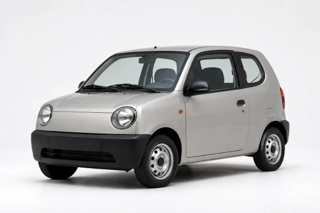 A small silver three-door hatchback with round headlights, black bumpers and ordinary steel wheels.